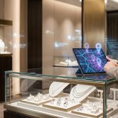 Gérante de bijouterie utilisant une tablette tactile avec une carte interactive pour optimiser sa stratégie locale.