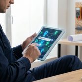 Un électricien utilise une tablette pour rechercher des chantiers sur une carte interactive.