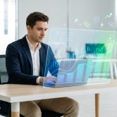 Un entrepreneur travaillant sur un ordinateur portable affichant des graphiques de croissance financière en réalité augmentée.