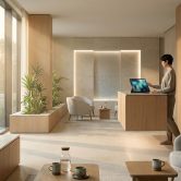 Réception lumineuse d'un spa moderne avec comptoir en bois, plantes d'intérieur et mobilier minimaliste épuré.
